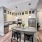 Spacious apartment kitchen with floating island, floor-to-ceiling cabinets, stainless steel appliances, and designer lighting