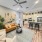Apartment living area with couch, carpet, plants, and kitchen in background
